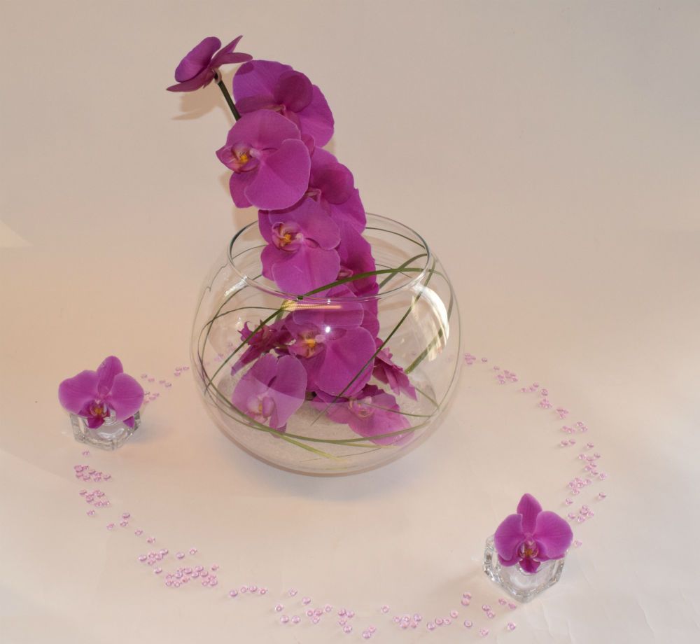 Aquarium aux orchidées fuchsia pour décoration de table mariage