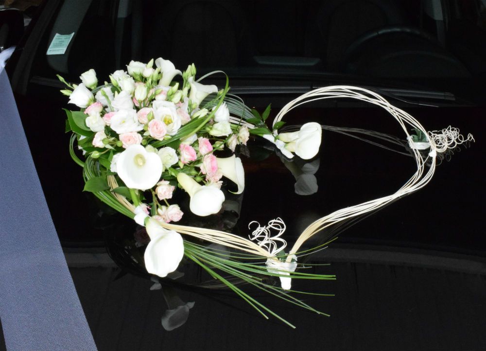 Cœur osier décoré de fleurs sur capot de la voiture des mariés pour mariage romantique